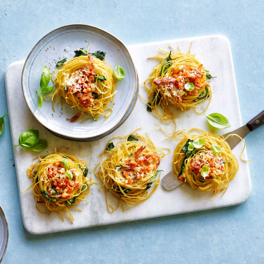 Nids de spaghetti aux légumes et au jambon cru