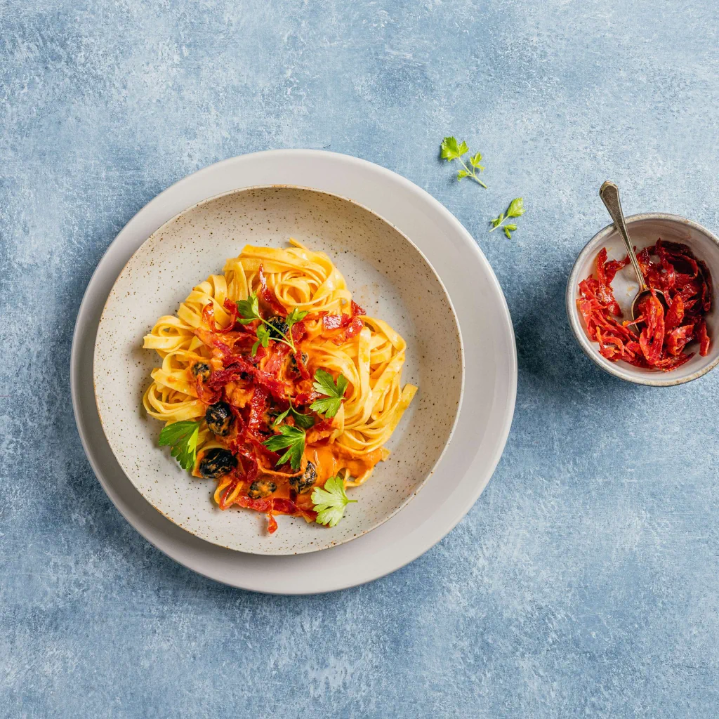 Tagliatelle al sugo di pomodoro con salame e formaggio fresco