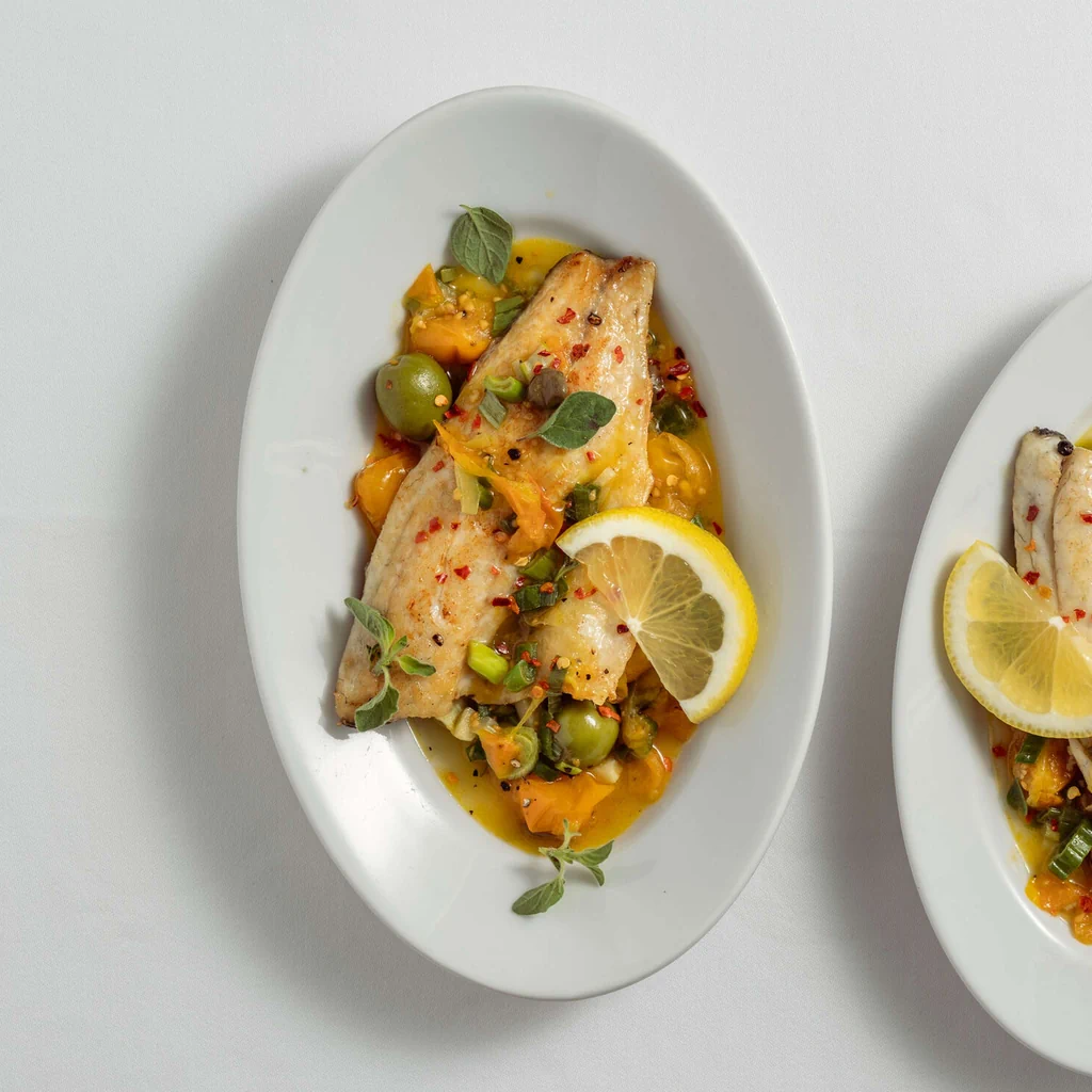 Filet de poisson sur tomates aux câpres avec olives