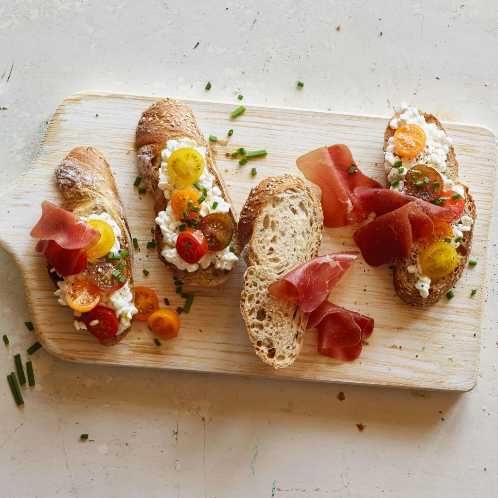 Tartine con cottage cheese, pomodori e carne secca