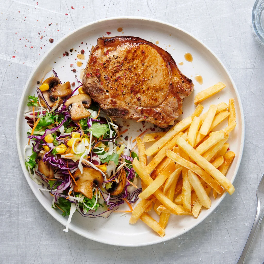 Schweinskotelett mit Pommes frites und Salat