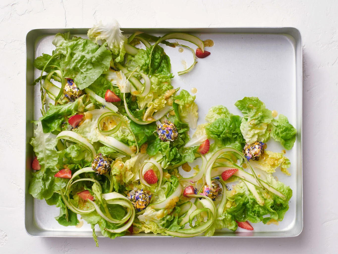 Insalata verde con asparagi, fragole e biglie di formaggio di capra