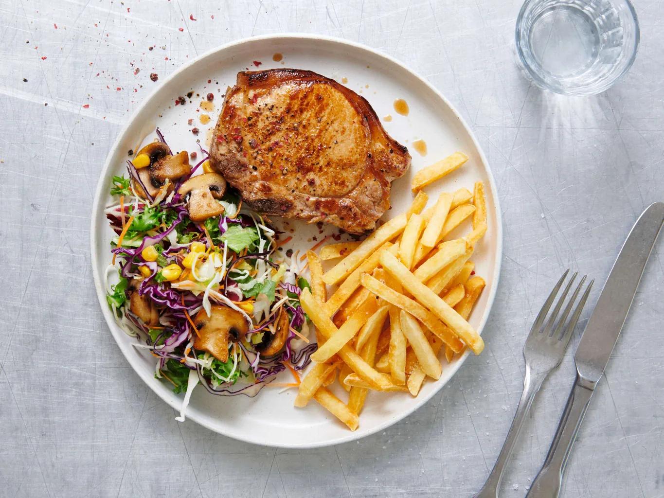 Schweinskotelett mit Pommes frites und Salat