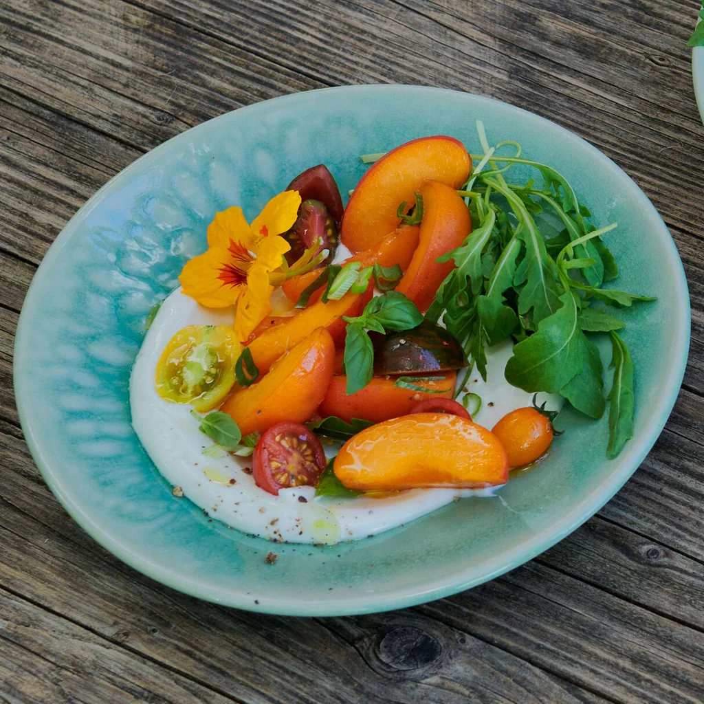 Formaggio di capra con insalata di albicocche e pomodori