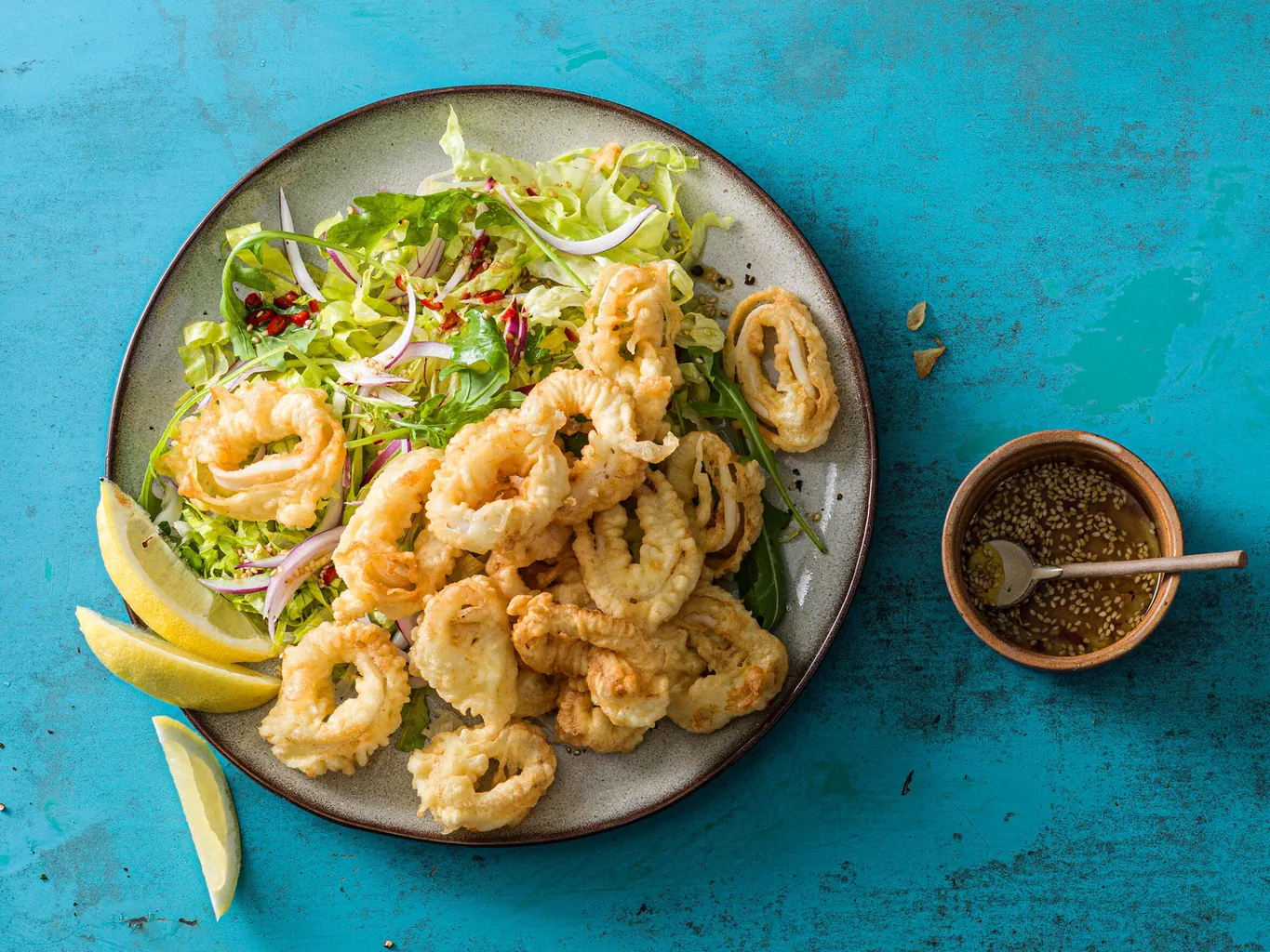 Anneaux de calamars sur laitue romaine avec sésame