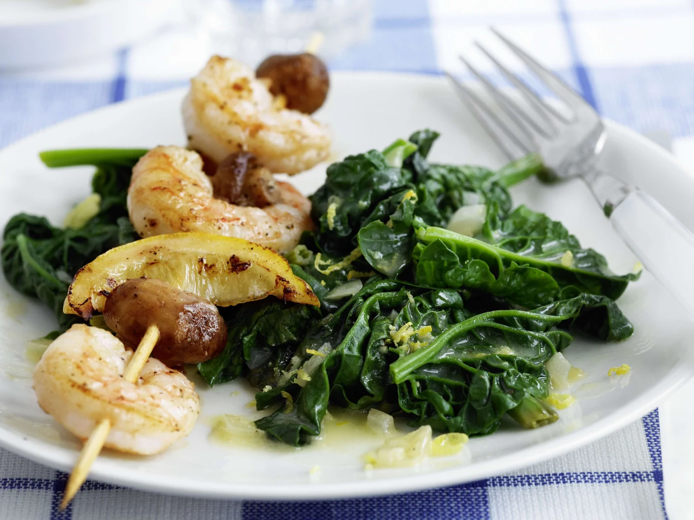 Spiedini di scampi su letto di spinaci al limone