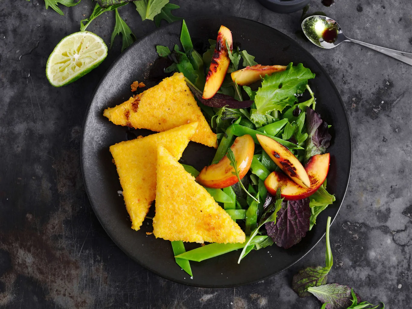 Triangoli di polenta su insalata di taccole e pesche