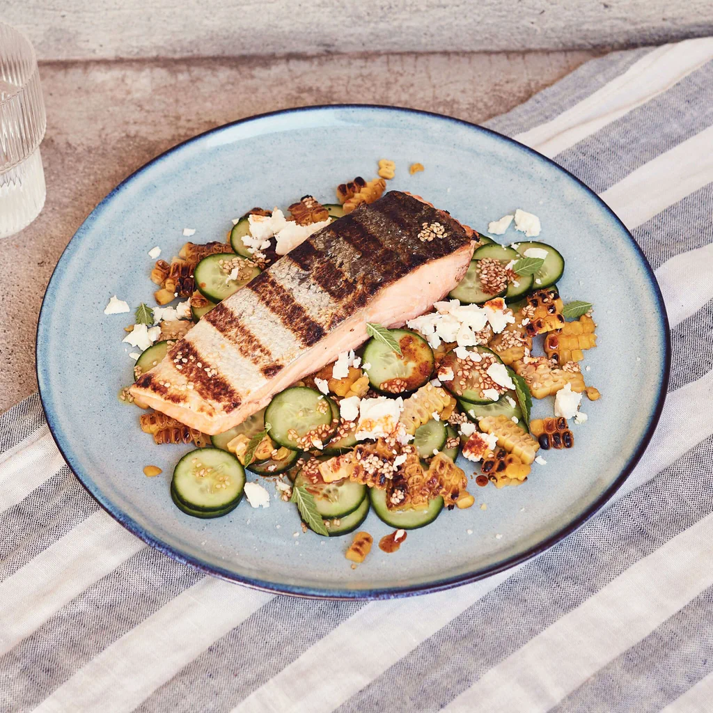 Saumon sur salade de concombre et de maïs grillé avec feta