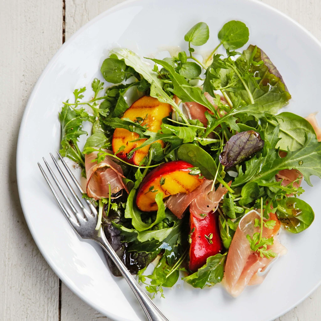 Salade de pousses avec jambon cru, pêches et thym