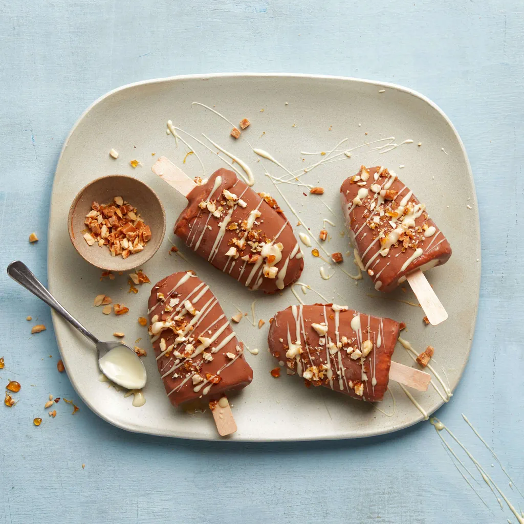 Bâton glacé au caramel enrobé de chocolat aux éclats de noisette