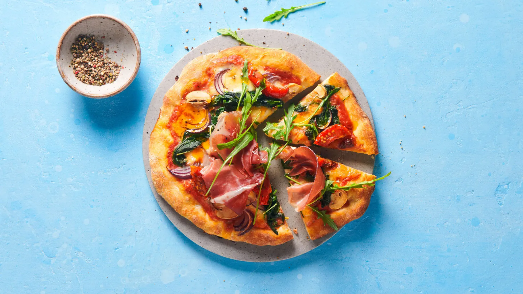 Pizza mit Spinat und Rohschinken