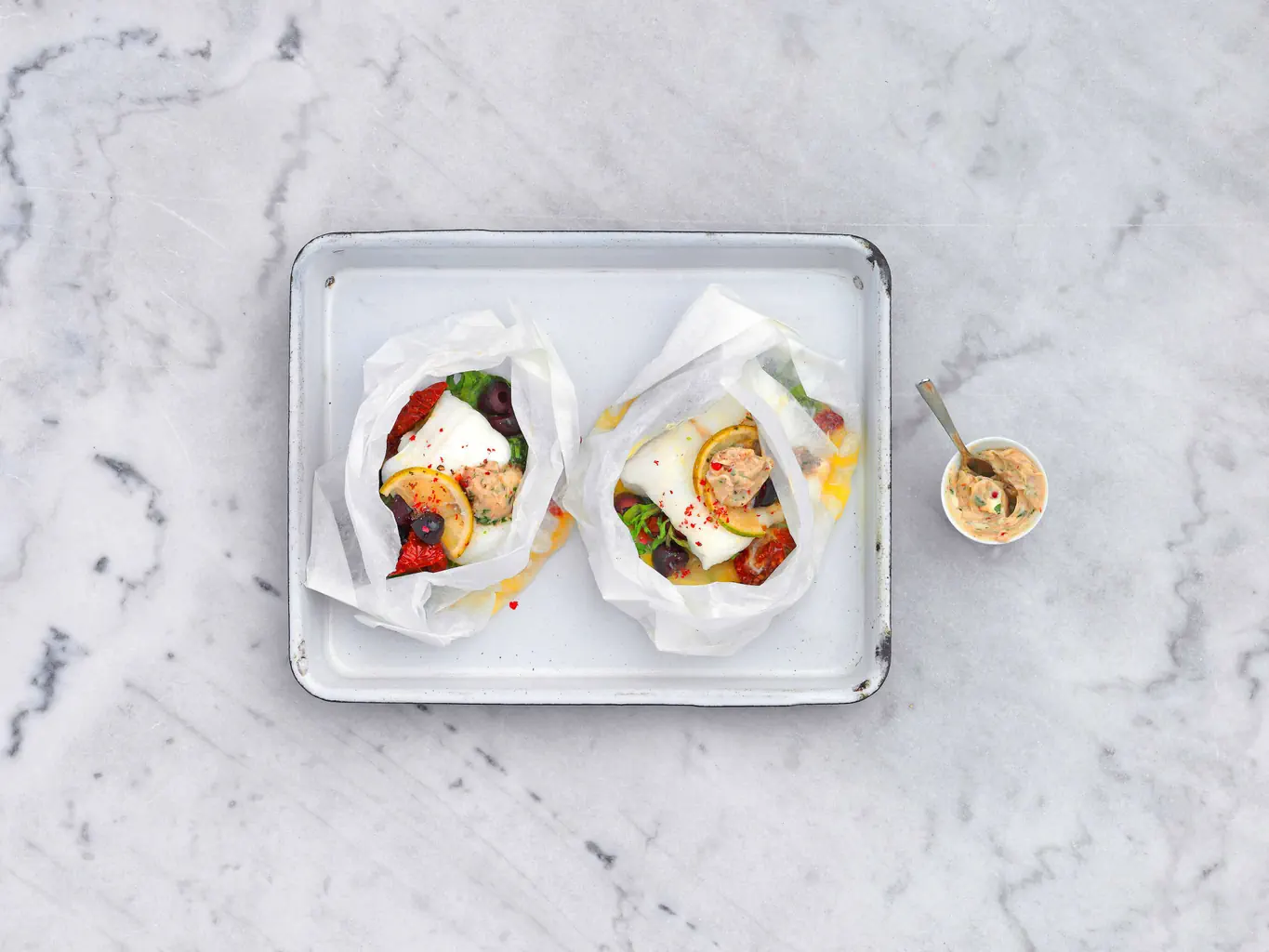 Filetti di pesce al cartoccio con olive e burro al balsamico