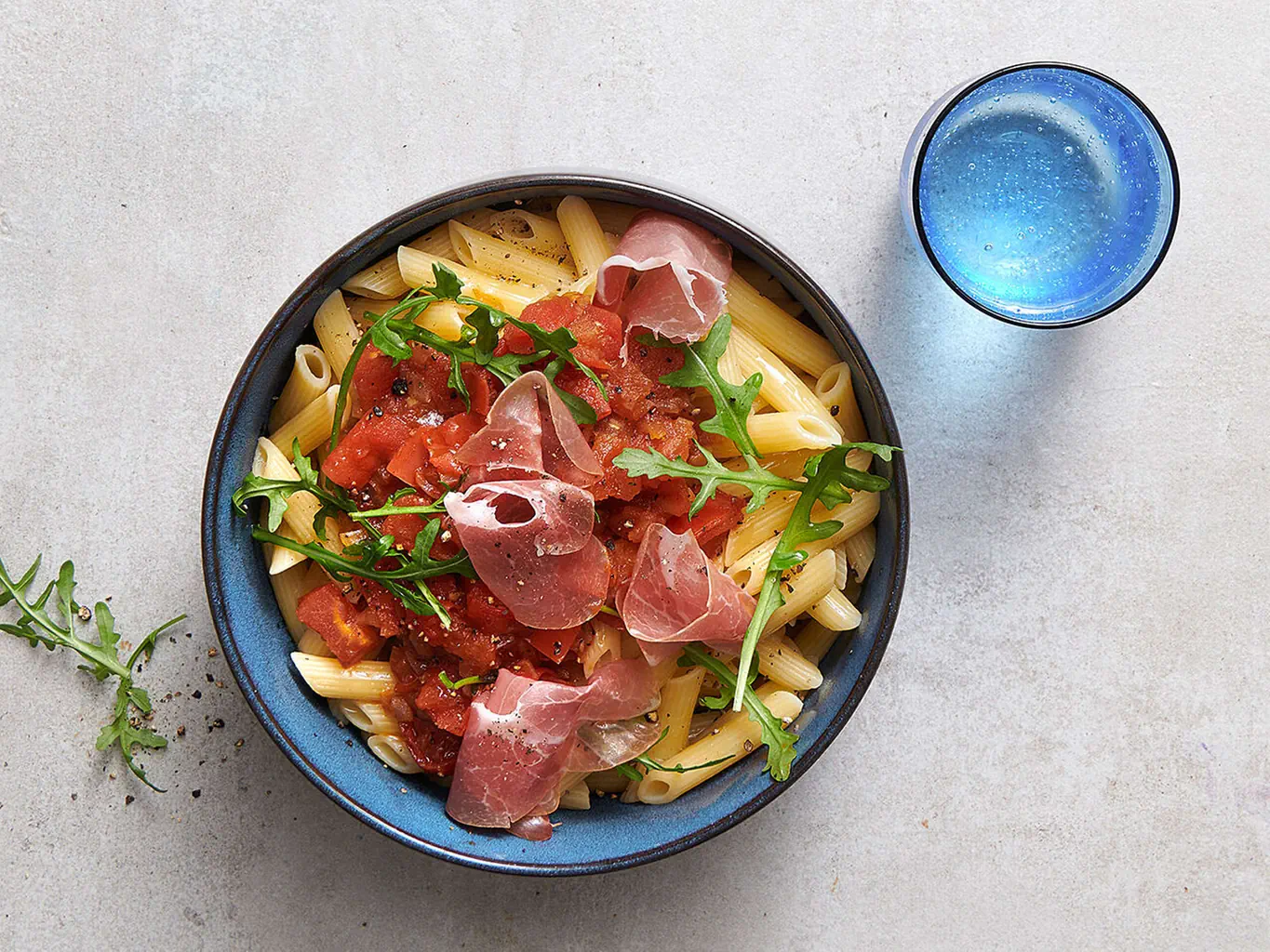 Penne con pomodori, rucola e prosciutto crudo