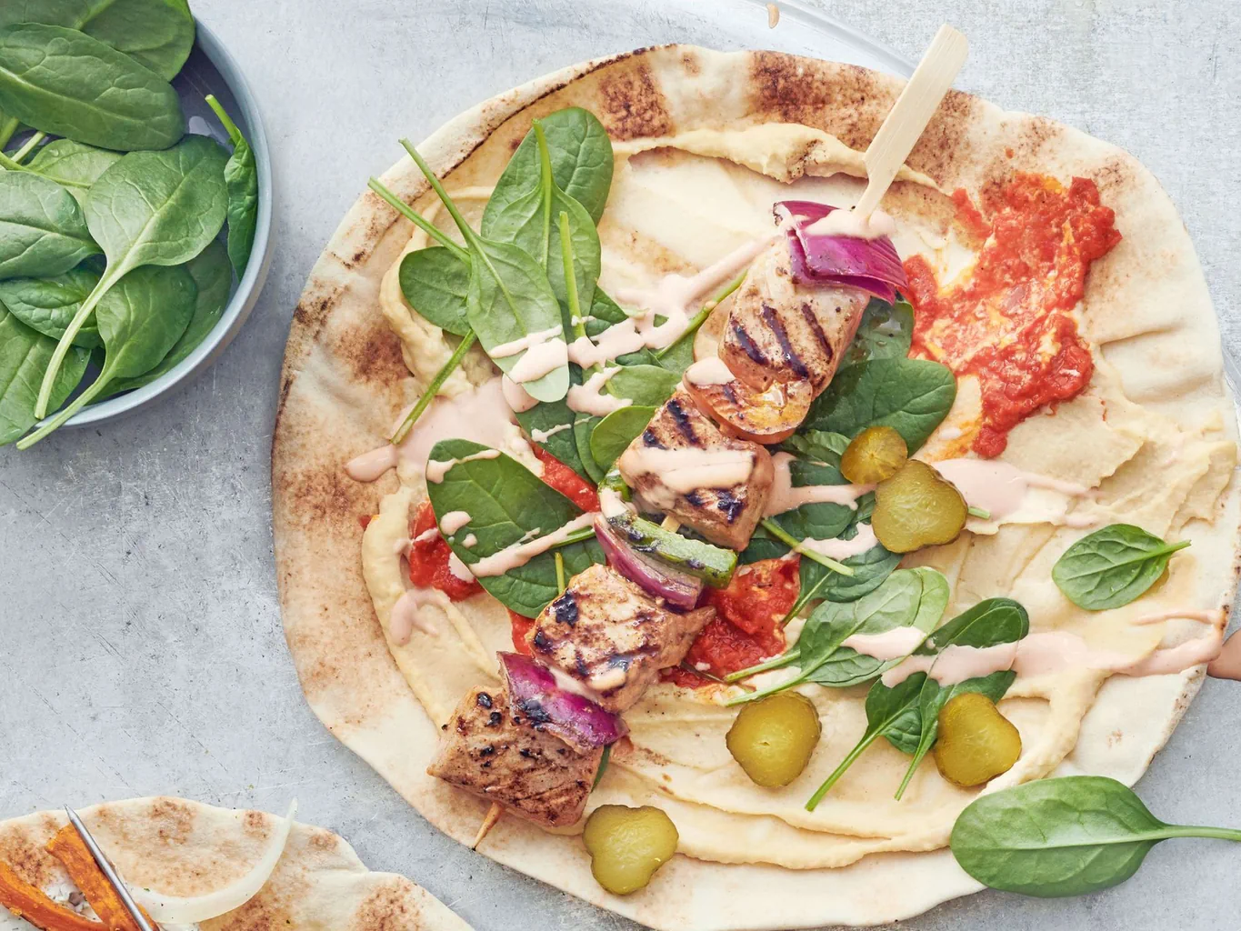 Pane arabo con spiedini di maiale, hummus e salsa cocktail